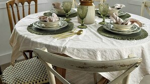 A dining room with a round table, white chairs, and a vase with dried flowers. - Design rustic villa in Alcaucín with pool (29713, Málaga)