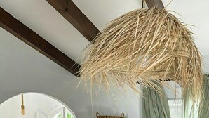 A room with a green cabinet, a hanging basket, a sofa, and a dining area with chairs and a table. - Design rustic villa in Alcaucín with pool (29713, Málaga)