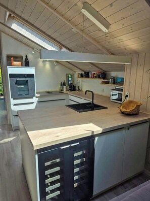 A modern kitchen with a central island, built-in appliances, and a view to the outdoors.