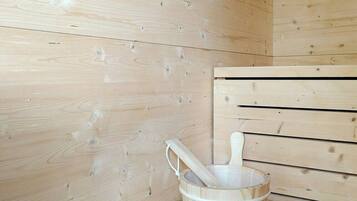 Een houten sauna met een houten emmer en een houten handvat.