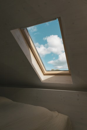 A room with a skylight, a bed, and a view of the sky. - Studio with balcony at Mühlenberg Werder (Werder (Havel))