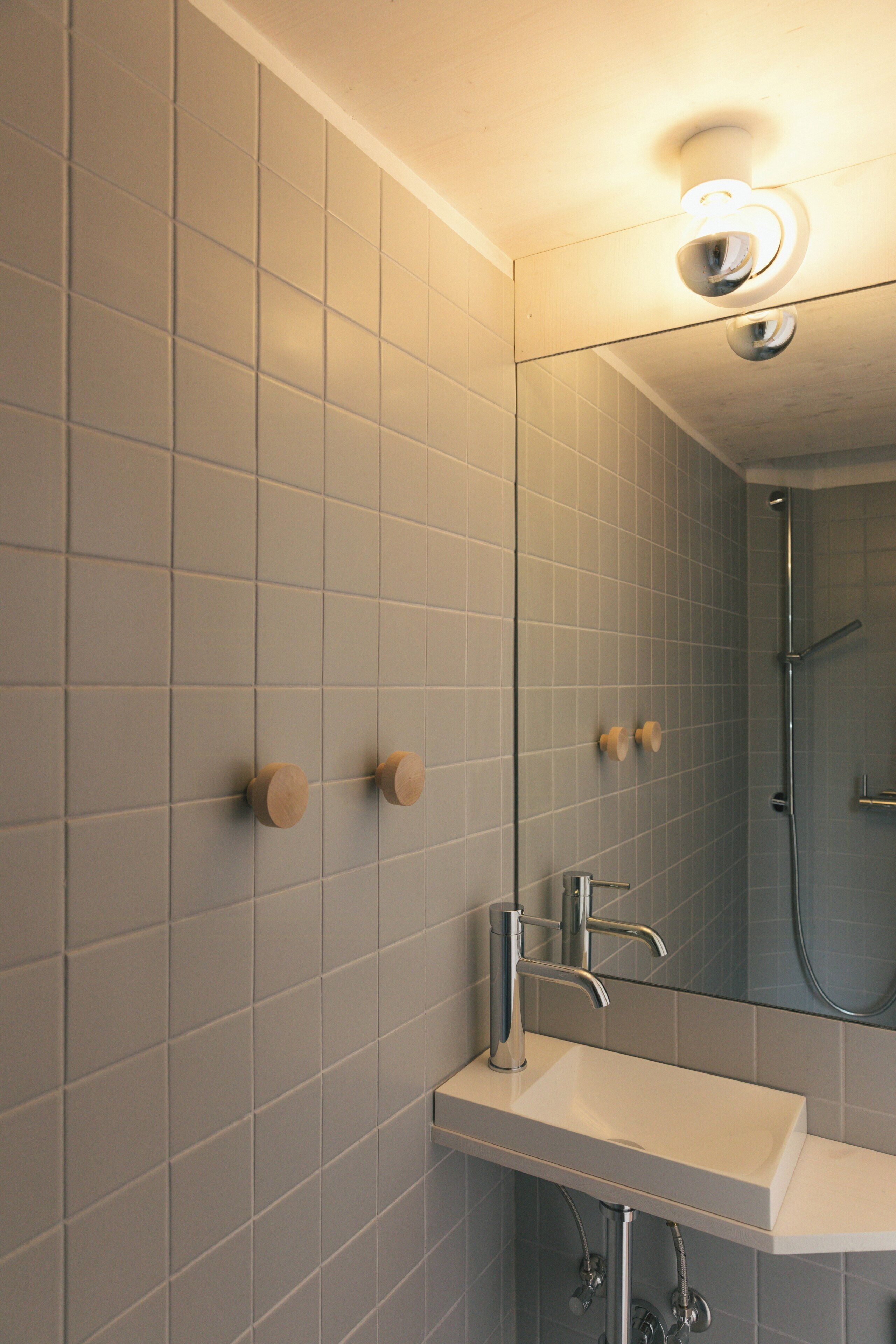 A bathroom with a white sink, a mirror, and a shower.