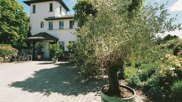 Ein Gebäude mit einem gepflasterten Innenhof, einem Blumentopfbaum und einem Fahrrad.