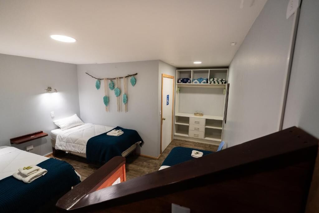 Ein Schlafzimmer mit zwei Betten, einem Kleiderschrank und einem kleinen Schreibtisch.