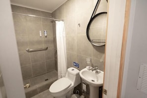 A bathroom with a shower, toilet, and sink.