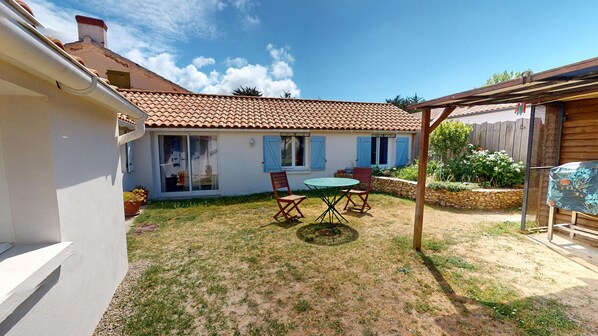 A residential property with a patio, a covered seating area, and a garden. - Roche aux Mouettes - House 100m² and large garden (Saint-Jean-de-Monts)