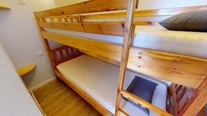 A bunk bed with a wooden frame, a mattress, and a pillow. - Le Spot des Becs (Saint-Hilaire-de-Riez)