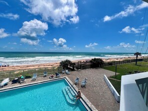 A pool area with a view of the beach and ocean. - VAN LEE BEACH CONDO 204!!!! (Ormond Beach)