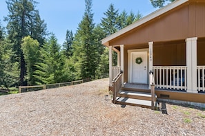 Een lodge met een veranda, een deur met een krans, en het nummer '10940' op de muur.