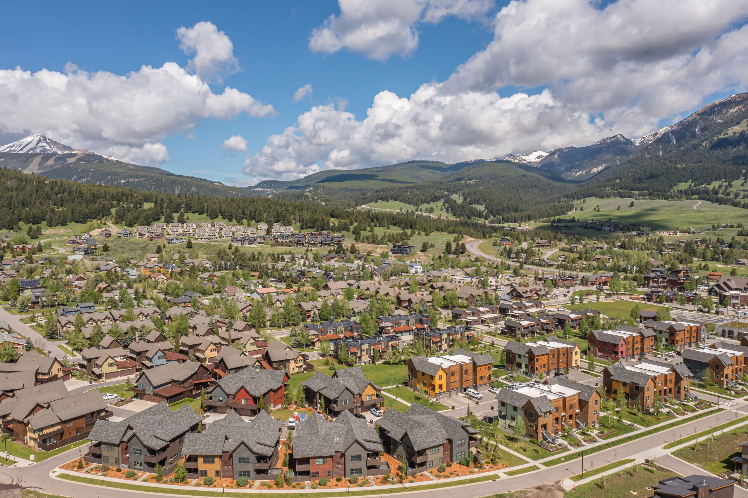 A residential area with houses, roads, and mountains in the background.