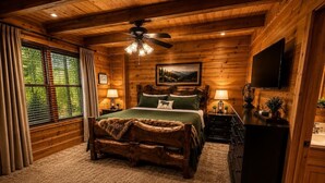 Ein schlicht eingerichtetes Schlafzimmer im Chalet-Stil mit einem Bett, einem Deckenventilator, einem Fernseher und einem Fenster mit Vorhängen.