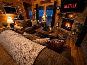 Ein gemütliches Wohnzimmer mit Ledersofas, einem Couchtisch, einem Kamin und einem Fernseher, der 'NETFLIX' anzeigt.