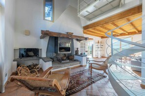 A spacious living area with a fireplace, wooden furniture, and a spiral staircase. - Farmhouse on working farm near Lake Como (Lecco)