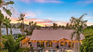 A house with a swimming pool, surrounded by greenery and palm trees. - Sandpiper by Nest Villas | 5BR Estate | Large Pool (Indio)