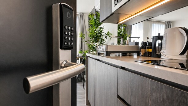 A modern kitchen with a built-in oven, a coffee machine, and a sleek door handle. - General Bulnes 259 (Santiago)