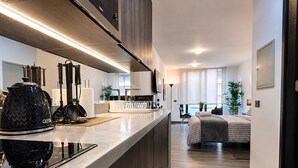 A modern kitchen with a built-in stove, a coffee maker, and a dining area with a table and chairs. - General Bulnes 259 (Santiago)