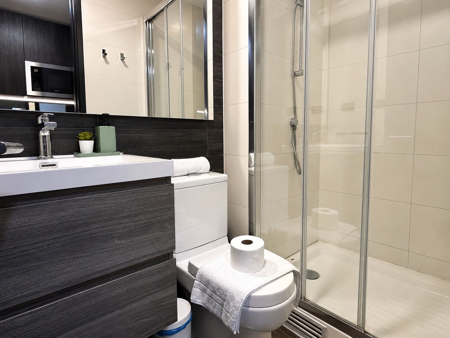 Un baño moderno con ducha, inodoro y lavabo.