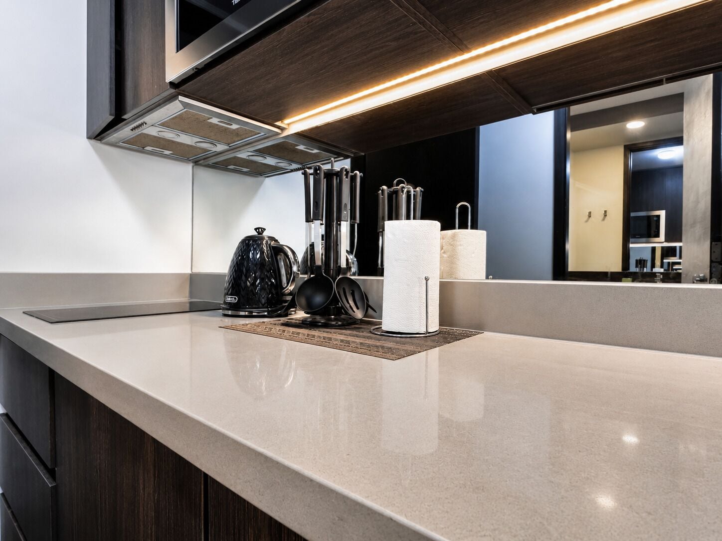 Una cucina moderna con un piano di lavoro elegante, un bollitore, una macchina da caffè e un portaserviti.