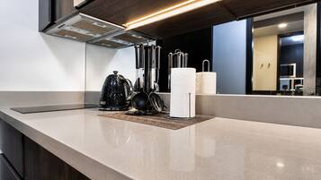 Una cucina moderna con un piano di lavoro elegante, un bollitore, una macchina da caffè e un portaserviti.