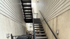 Un escalier étroit avec des rampes en métal et une cage d’escalier en métal.