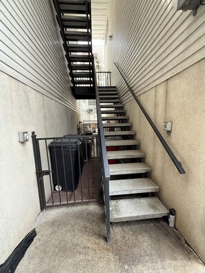Una escalera estrecha con barandillas y escalones metálicos.