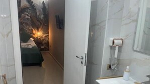 A bathroom with a toilet, sink, and shower area. - Pisacane Family Sea (Naples)