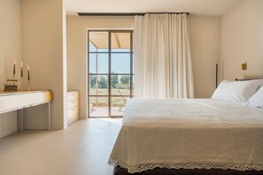 Ein Schlafzimmer mit Bett, Schreibtisch und einem Fenster mit Vorhängen.