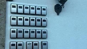A wall-mounted light fixture and a row of doorbell buttons.