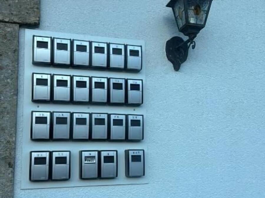 A wall-mounted light fixture and a row of doorbell buttons.