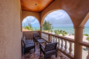 Ein überdachter Sitzbereich mit Blick auf Strand und Meer.