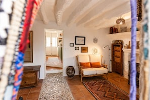 Ein gemütliches Wohnzimmer mit einer Couch, einem Kamin und einem Flur, der in einen anderen Raum führt.