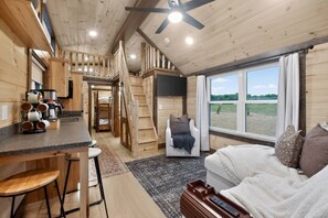 Ein Ferienhaus-Interieur mit Küche, Essbereich und einem gemütlichen Wohnzimmer mit großem Fenster.
