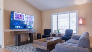 Ein Wohnzimmer mit Flachbildfernseher, Kamin, Sofa und Couchtisch.