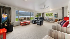 A spacious living room with a large window, a fireplace, and a television.