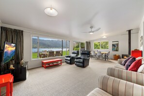 A spacious living room with a large window, a fireplace, and a television.