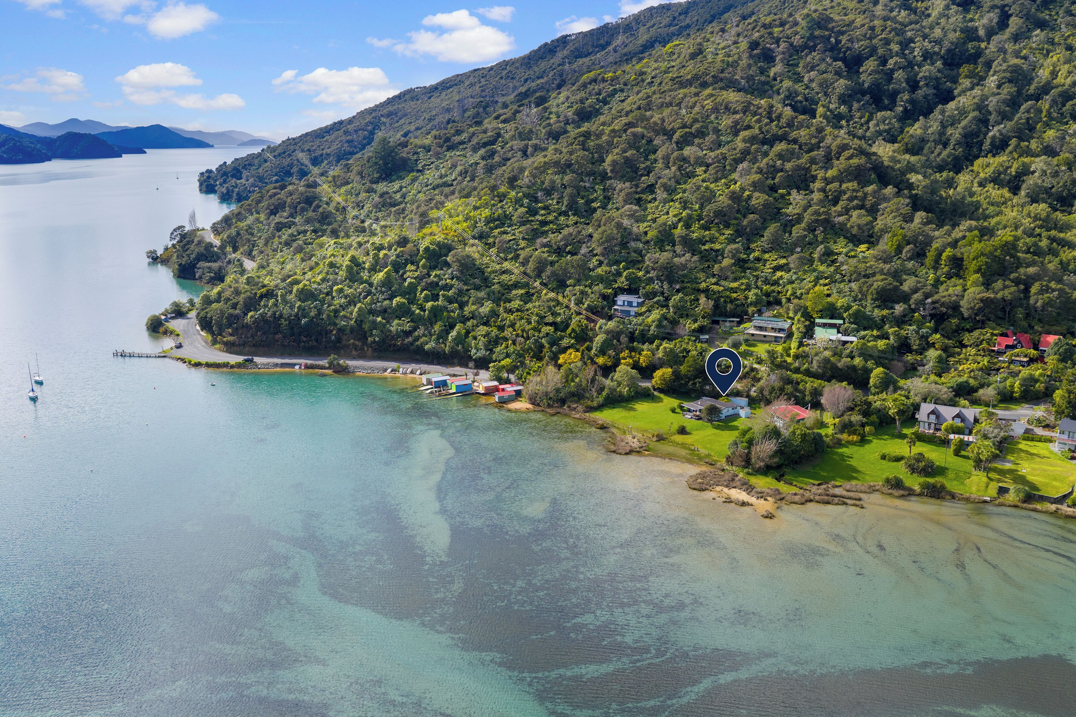 Une zone côtière comprenant un lac, des maisons et une colline boisée.