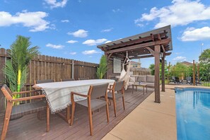 A wooden deck with a pool, outdoor furniture, and a pergola. - 5-bd/2.5-ba With Pool, Hot Tub, Cinema & Golf Sim (Royse City)