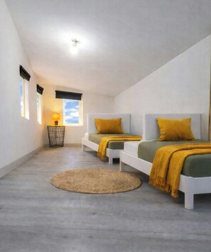 A bedroom with two beds, a round rug, a lamp, and a window with a view. - Artist's house between sea and vineyards (Florensac)