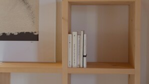 Een houten boekenplank met drie boeken.