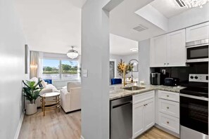 A modern kitchen with white cabinets, a stainless steel oven, and a built-in microwave. - Luxury Condo, Waterviews, Pools, 12PM Check In (Myrtle Beach)