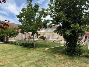 A stone building with a garden, outdoor seating, and a pathway. - Family-friendly apartment with a pool on Caminho Santiago (D) (Macieira da Maia)