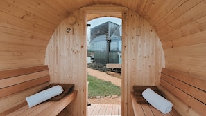Una sauna con bancos de madera y vistas a un edificio cercano.
