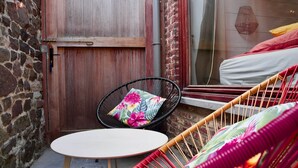A cozy outdoor seating area with a round table and two wicker chairs, one with a floral cushion. - Costa Rica - Tropical immersion (Profondeville)