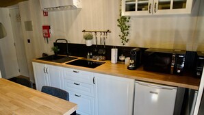 Cocina compacta con fregadero, estufa, microondas y armarios.