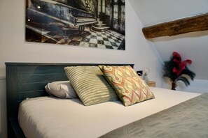 Ein Bett mit Kopfteil, zwei Kissen und einem dekorativen Kissen mit geometrischem Muster.