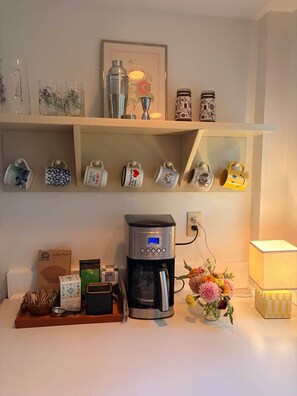 A coffee station with a coffee maker, mugs, and coffee filters. - Dam Good Times - 90s Lake Getaway (Stoddard)