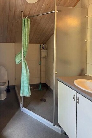 Une petite salle de bain avec une douche, des toilettes et un lavabo.