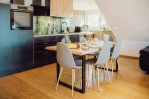 Eine moderne Küche mit Essbereich, Holzschränken und einem eingebauten Backofen.