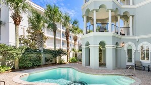 Ein Pool mit kreisförmigem Design, umgeben von einer Pflasterterrasse.