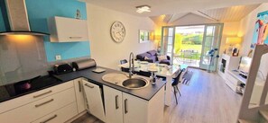 A modern kitchen with a sink, stove, and cabinets. - Violette, a pretty house in the heart of the golf (Talmont-Saint-Hilaire)